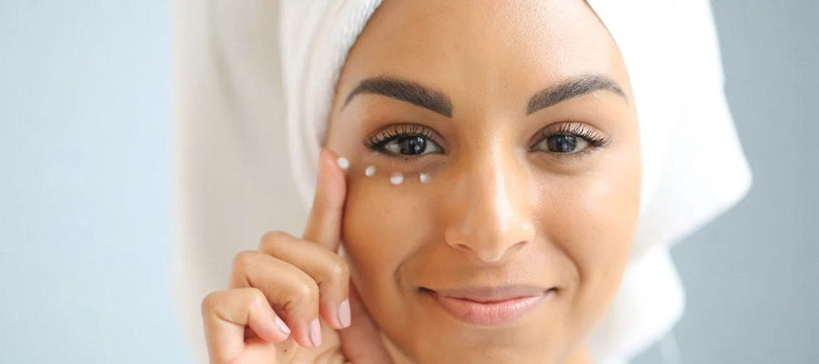 Woman draws 4 dots with eye cream under her eye