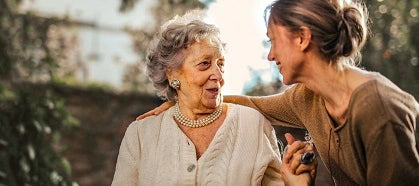 Woman and her mother holding hands and talking