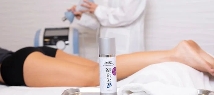 Woman's legs behind a bottle of ALASTIN's TransFORM Body Treatment product