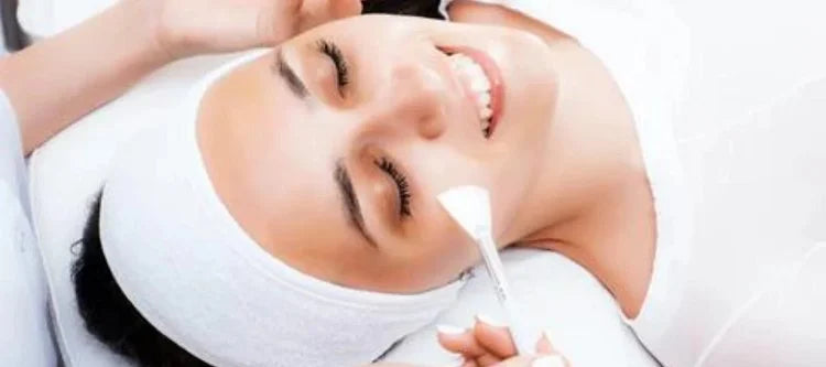 Dermatologist lightly brushing woman's face