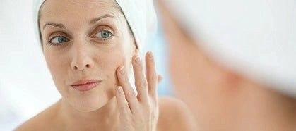 Woman in bathroom applying moisturizing cream