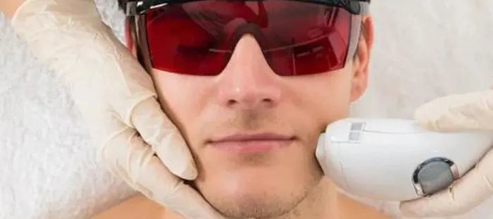 Man in red glasses getting laser treatment on his face