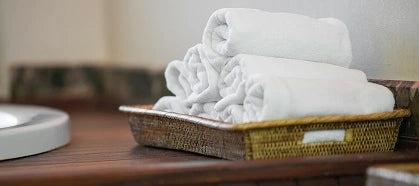 Stack of white towels rolled up on tray