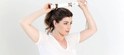 Woman curling hair with curling iron