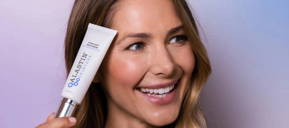 Woman with ALASTIN product on face against purple background