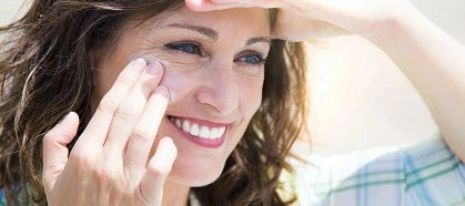 Woman applying sunscreen to face